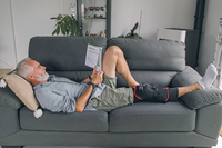 pa-DonJoy-82-0166-KNEE-UNIVERSAL-ICE_Homme-allongé-canapé-lecture.png__PID:5ad0c077-e18d-43ef-a1dd-163493583849